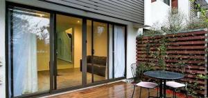 Un patio con una mesa y sillas junto a una pared de ladrillo. en Spacious Family Townhouse near Kingston & Manuka, en Fyshwick