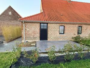 a brick house with a black door in a yard at Duplex neuf et cosy vue Mont des Cats in Météren +19 photos