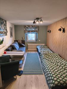 una sala de estar con un sofá y una cama en Osmelakowa Dolina, en Spalona
