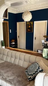 a living room with a couch and a blue wall at Marios House in Kini
