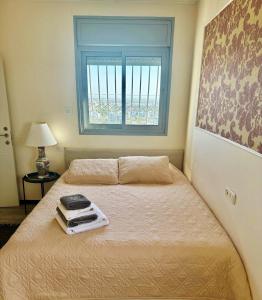 a small bedroom with a bed with a window at Open-space apartment by the SEA in Ashdod