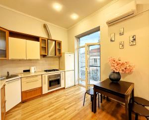 uma cozinha com uma mesa com um vaso de flores sobre ela em Kyiv Sakura Apartment em Kiev