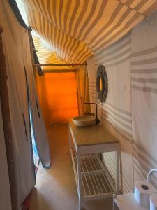 a bathroom with a sink and a table in a room at Le xury camp in Hassilabied
