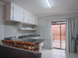 Uitspan No 5 في سانت لوسيا: مطبخ مع خزائن بيضاء وطاولة وكراسي +4 صور