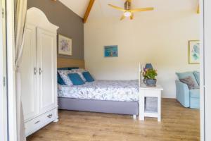 een slaapkamer met een bed en een plafondventilator bij Woubrugge Logies in Woubrugge