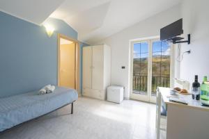 a bedroom with a bed and a kitchen with a balcony at Palia's Hotel in Laino Borgo