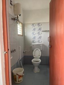 a small bathroom with a toilet and a shower at Radiant Hill Homestay in Kodaikānāl +44 photos