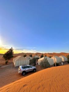 a car parked in the middle of a desert at Camel luxury camps Merzouga in Merdani