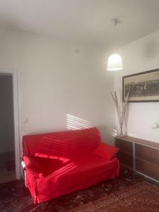 a red couch sitting in a living room at Tamika's House in Udine