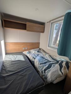 Кровать или кровати в номере Mobilhome 3 chambres dans camping 4 étoiles
