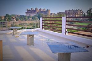 two benches in front of a fence with a view at hotelsiyashreeram in Orchha