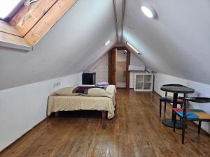 a attic bedroom with a bed and a table at חאן בשביל היער in Ta‘oz