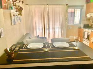 a dining room table with two glasses and plates on it at Alquiler por dia "Como en Casa" Caseros, cerca de Palomar y Hurlingham in Caseros