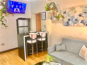 a living room with a couch and a bar with stools at Alquiler por dia "Como en Casa" Caseros, cerca de Palomar y Hurlingham in Caseros +28 photos