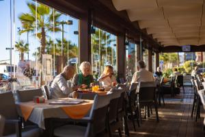 a group of people sitting at tables in a restaurant at Apartamentos La Jabega in Fuengirola