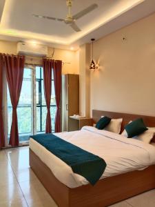 a bedroom with a large bed in front of a window at Aamaya Inn in Haldwāni