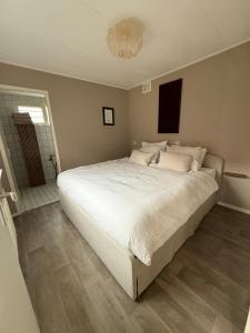 Un dormitorio con una gran cama blanca. en Bed & Bloom, en Barneveld