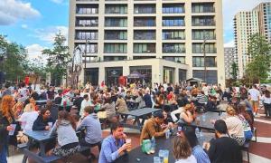 una multitud de personas sentadas en las mesas frente a un edificio en Luxurious and Spacious Central London room in Canary Wharf with a City View & a Private Bathroom, en Londres