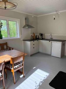a kitchen with a wooden table and a table and chairs at Huisje weltevreden in Ekshärad