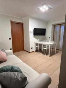 Una sala de estar con una mesa y un televisor. en Arlecchino Apartment di Manenti Andrea, en Oltre il Colle 13 fotos más