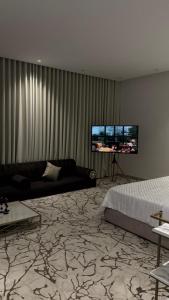 a living room with a couch and a flat screen tv at المدينه المنوره in Al Madinah