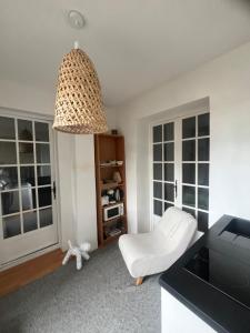 Le Verger في آكس أون بروفانس: غرفة معيشة بها كرسي أبيض ومصباح معلق