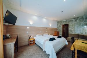 a hotel room with a bed and a flat screen tv at Pensjonat Borowik in Jelenia Góra-Jagniątków +35 photos