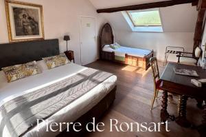 a bedroom with a bed and a desk and a table at Domaine de la Butte Ronde in La Boissière-École +24 photos