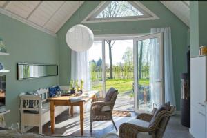 een woonkamer met een tafel en stoelen en een raam bij Ferienhaus Clara in Wardenburg