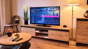 Televiisor ja/või meelelahutuskeskus majutusasutuses MADISON Homes Apartment 50 qm in Prien mit Balkon, Bergblick, Parkplatz, zentral gelegen