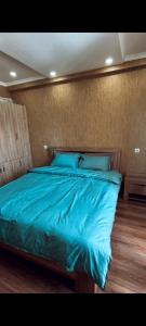 a bed with a blue comforter in a bedroom at Horizont-apartment11 in Bakuriani +2 photos