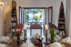 a dining room with a table with a view of the ocean at Waterlovers Beach Resort in Diani Beach