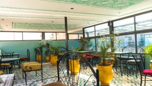 a restaurant with tables and chairs and plants at Riad Green House in Fez