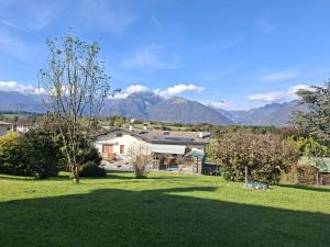 a house in a field with mountains in the background at Belvedere 160 in Feltre
