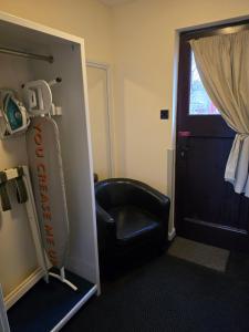 Una habitación con una silla de cuero negro y una puerta. en The Mill Forge Hotel, en Gretna Green