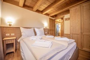 een slaapkamer met een bed met handdoeken erop bij Chalet Abete in Livigno +22 foto's