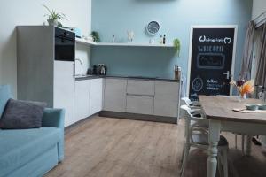 een keuken en woonkamer met een tafel en een bank bij Woubrugge Logies in Woubrugge +15 foto's