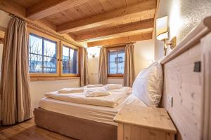 een slaapkamer met een bed en twee ramen bij Chalet Abete in Livigno