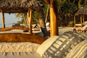 a view of a beach with chairs and umbrellas at Waterlovers Beach Resort in Diani Beach