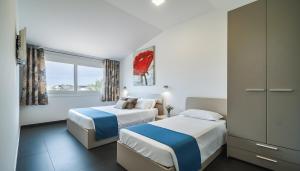 ein Hotelzimmer mit zwei Betten und einem Fenster in der Unterkunft Villa Dell'Ulivo con piscina privata By Sicily Home Solutions in Alcamo + 31 Fotos