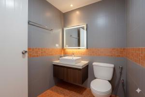 a bathroom with a toilet and a sink and a mirror at Suchanan Serviced Apartment โรงแรมสุชานันท์ in Ban Chang +40 photos