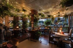 a restaurant with tables and chairs and plants at Suchanan Serviced Apartment โรงแรมสุชานันท์ in Ban Chang