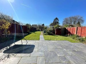 Cozy Guest Room in Family Home, Close to Aldershot Town Centre في ألدرشوت: فناء مع طاولة في منتصف الفناء