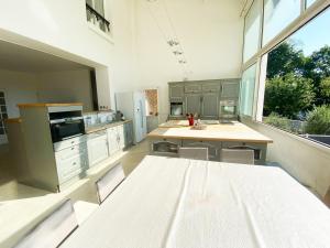 cocina con mesa y sillas y ventana grande en Charmante Maison partagée à 5 min d'Orly et 15 min de Paris, en Athis-Mons