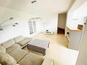 una sala de estar con un sofá y una mesa en Charmante Maison partagée à 5 min d'Orly et 15 min de Paris, en Athis-Mons