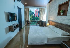 a bedroom with a white bed and a brick wall at Atholi Residency in Mukkam