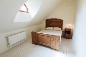 a bedroom with a wooden bed and a window at Pilsbrūzis in Odziena
