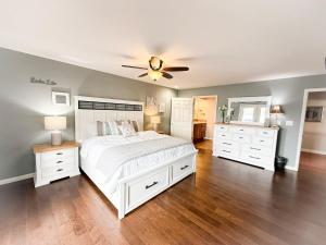 een slaapkamer met een wit bed en een plafondventilator bij Edgewater-Lakefront 3 BD25BADeckDockGril-16P in Laguna Beach