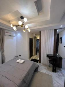 ラゴスにあるNike's Placeのベッドとテーブルとピアノのある寝室