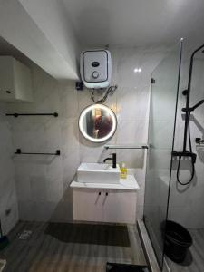 ラゴスにあるNike's Placeの白い洗面台と鏡のあるバスルーム